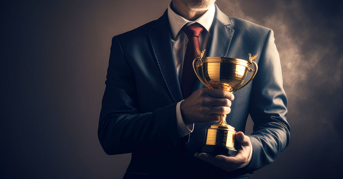 A successful individual businessman holds a trophy